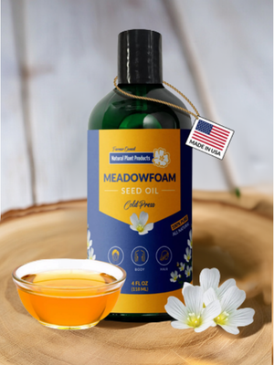 Pure Meadowfoam Seed Oil in amber glass bottle surrounded by white meadowfoam flowers, natural botanical hair and skin moisturizer from Oregon