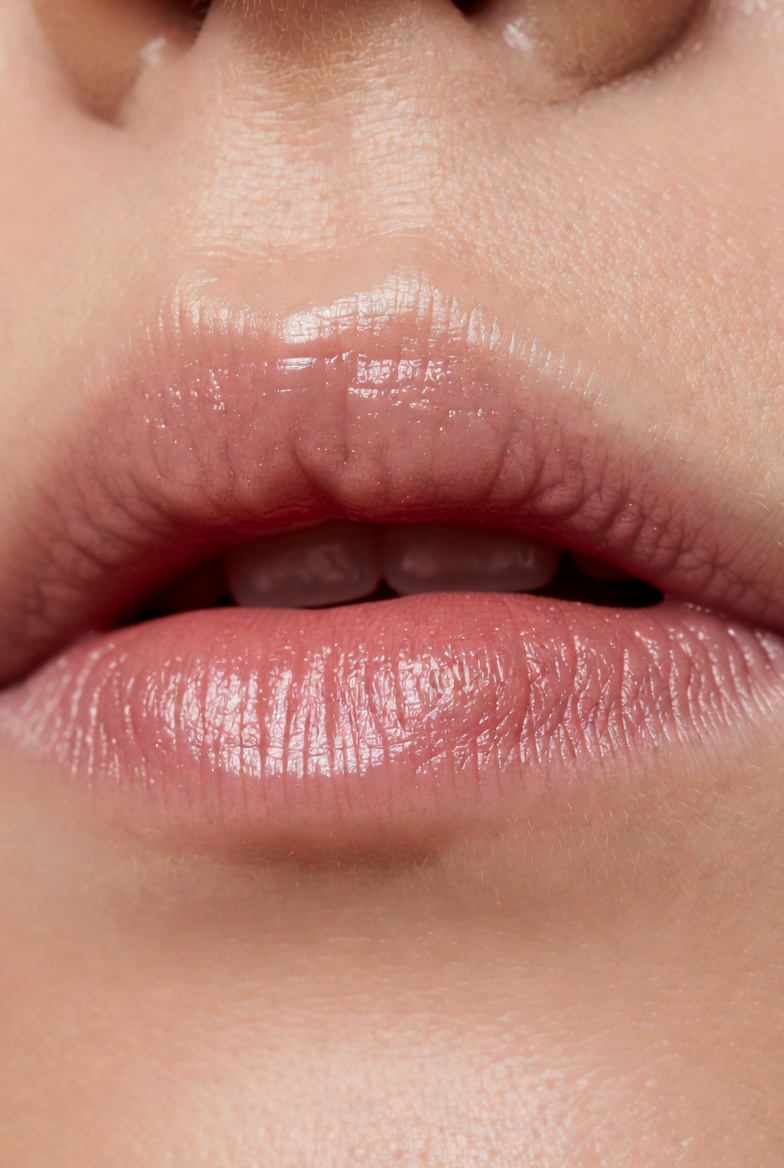 Close-up of soft, smooth, naturally hydrated pink lips with healthy shine from botanical lip oil, showing results of natural ingredients for dry chapped lips