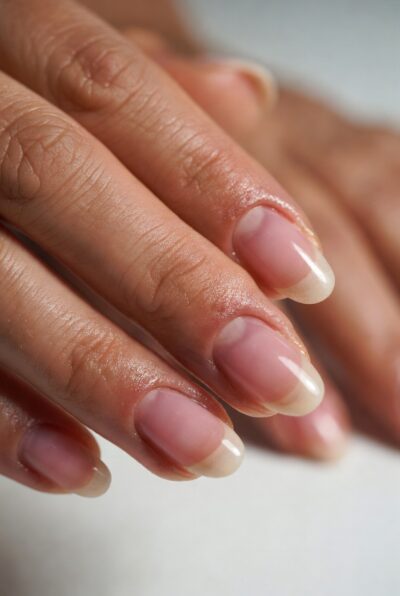 Close-up of woman's healthy hydrated nails with smooth soft cuticles showing natural shine and moisture from botanical nail oil, natural nail care results