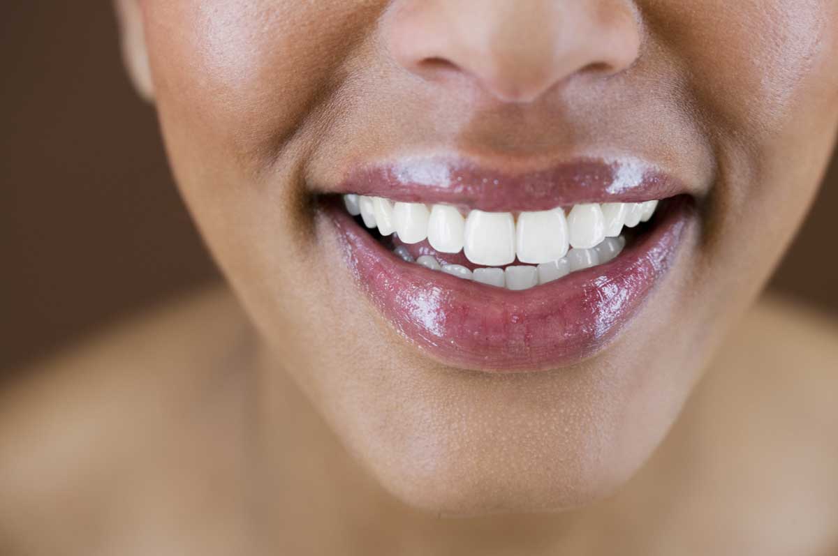 Two people inspecting meadowfoam flowers in a field to assess plant growth and seed quality